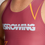 Close-up of a person wearing a maroon unisuit with a large white USROWING logo across the chest and yellow graphic accents.