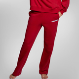 A person wearing red sweatpants and a matching red sweatshirt, shown from the waist down. The sweatpants have a small white USRowing logo on the left hip.