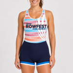 A woman modeling a rowing unisuit with a multicolor striped pattern on the top and navy blue bottoms with light blue and white trim. The front features the text 'LIGHTING ROWFEST NATIONAL CHAMPIONSHIPS' in navy blue.