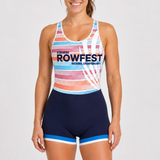 A woman modeling a rowing unisuit with a multicolor striped pattern on the top and navy blue bottoms with light blue and white trim. The front features the text 'LIGHTING ROWFEST NATIONAL CHAMPIONSHIPS' in navy blue.