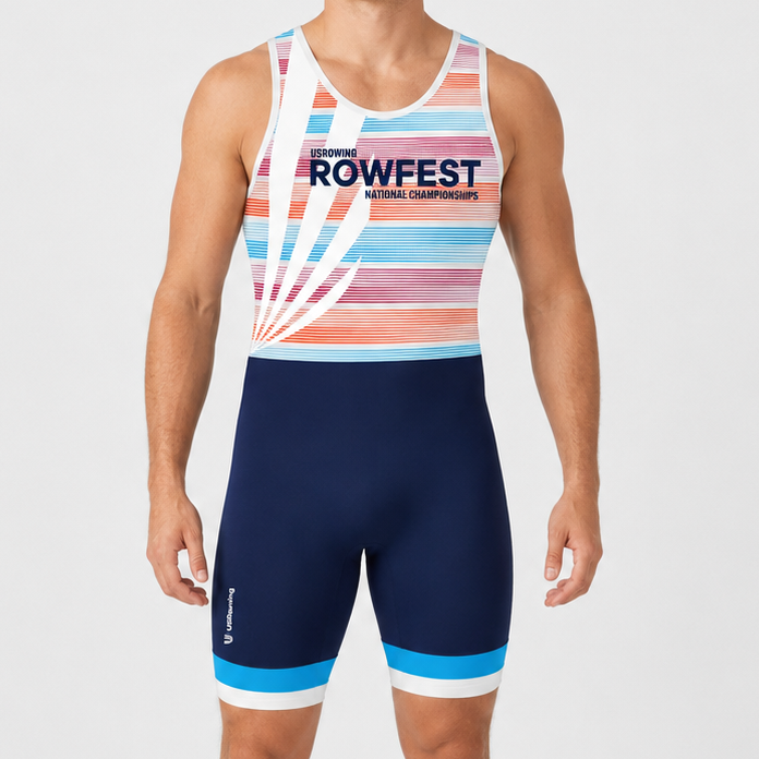 A male model wearing a sleeveless athletic rowing unisuit with a multicolor striped pattern on the top and navy blue shorts with light blue and white accents, standing against a light gray studio background.