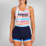A woman modeling a one-piece rowing uni with a white base, multicolor pastel stripes, and navy blue shorts with blue and white trim. The front of the top features the text 'SEMINING ROWFEST NATIONAL CHAMPIONSHIPS'.