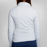 Back view of a woman wearing a light blue long-sleeve athletic top and navy blue trou.