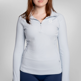 A woman wearing a light blue long-sleeve quarter-zip athletic top with a small USRowing logo on the left chest.