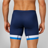 Rear view of a model wearing navy blue rowing trou with a white and light blue stripe detail at the hem, against a light gray studio background.